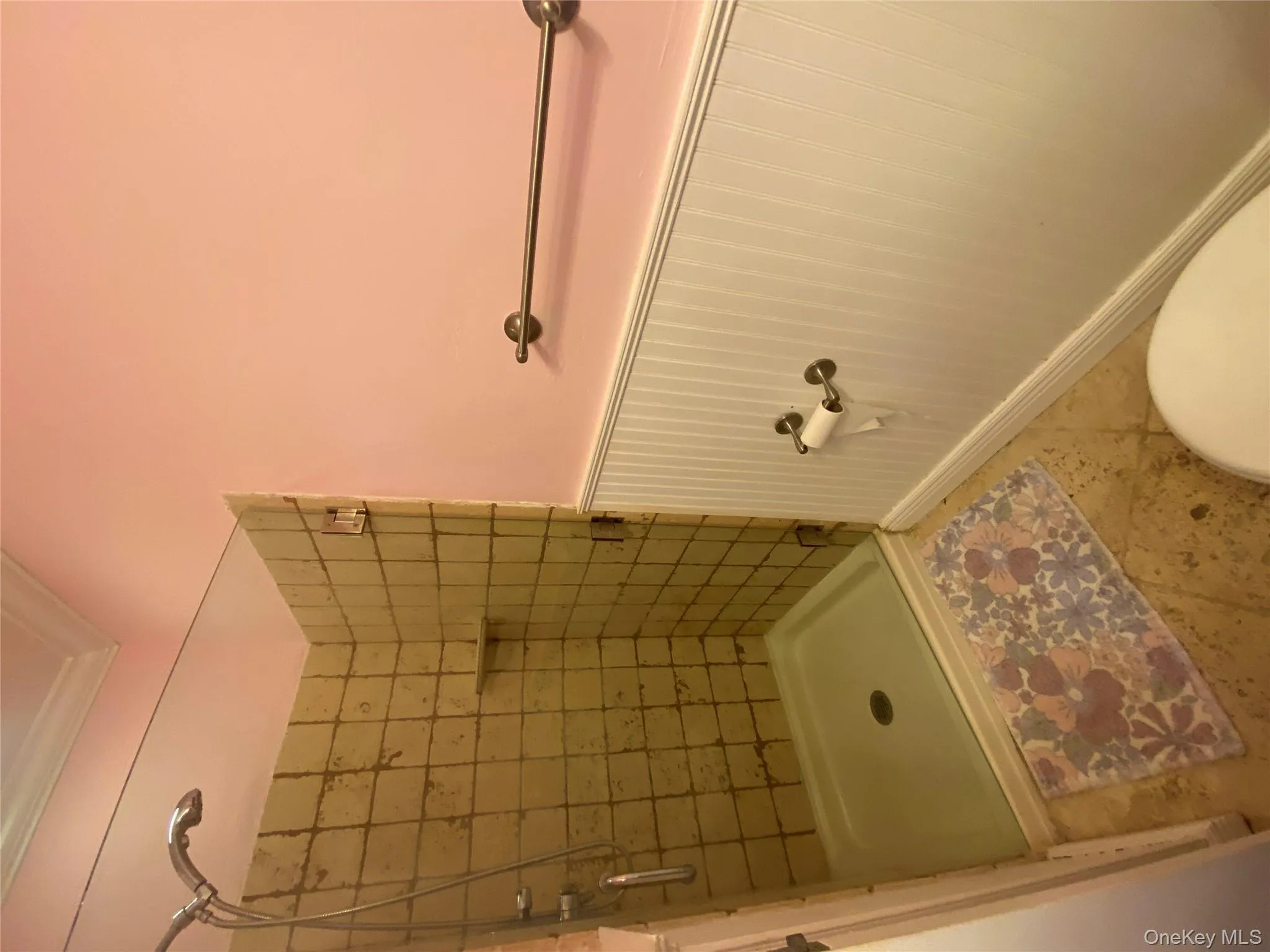 Full bathroom with a wainscoted wall, a stall shower, and ornamental molding Full bathroom with a wainscoted wall, a stall shower, and ornamental molding