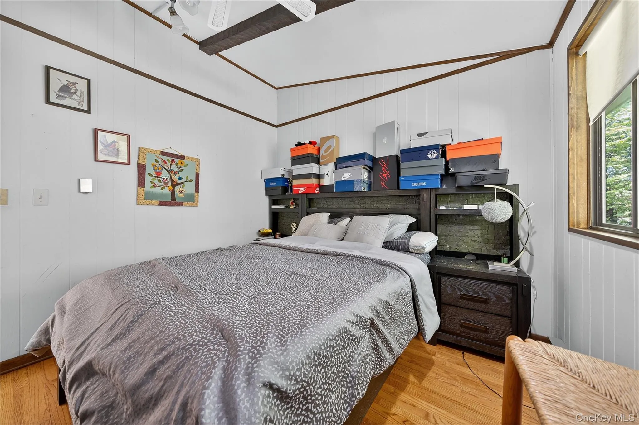 Bedroom featuring wood finished floors, wood walls, and crown molding Bedroom featuring wood finished floors, wood walls, and crown molding