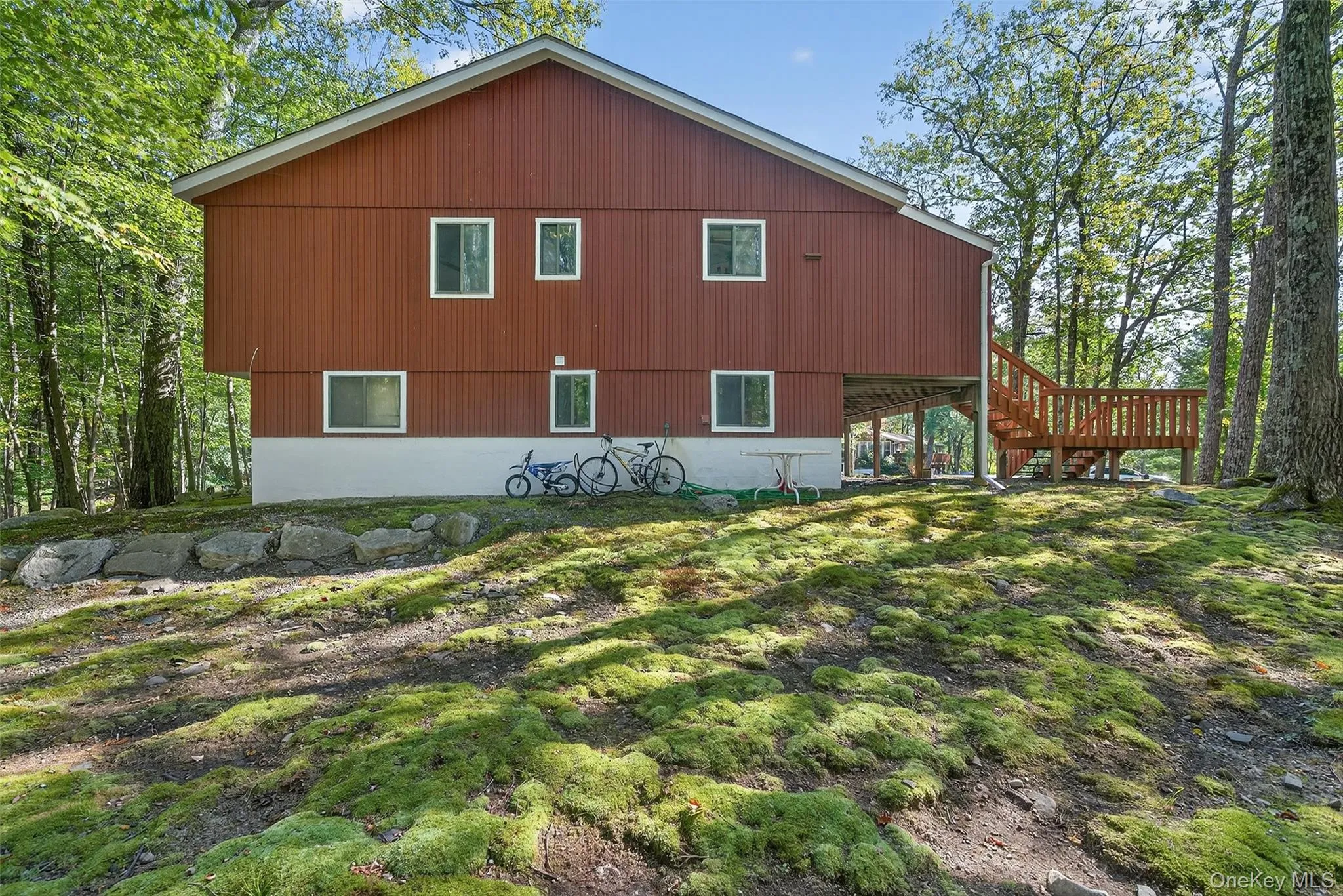 Rear view of property featuring a wooden deck and stairs Rear view of property featuring a wooden deck and stairs