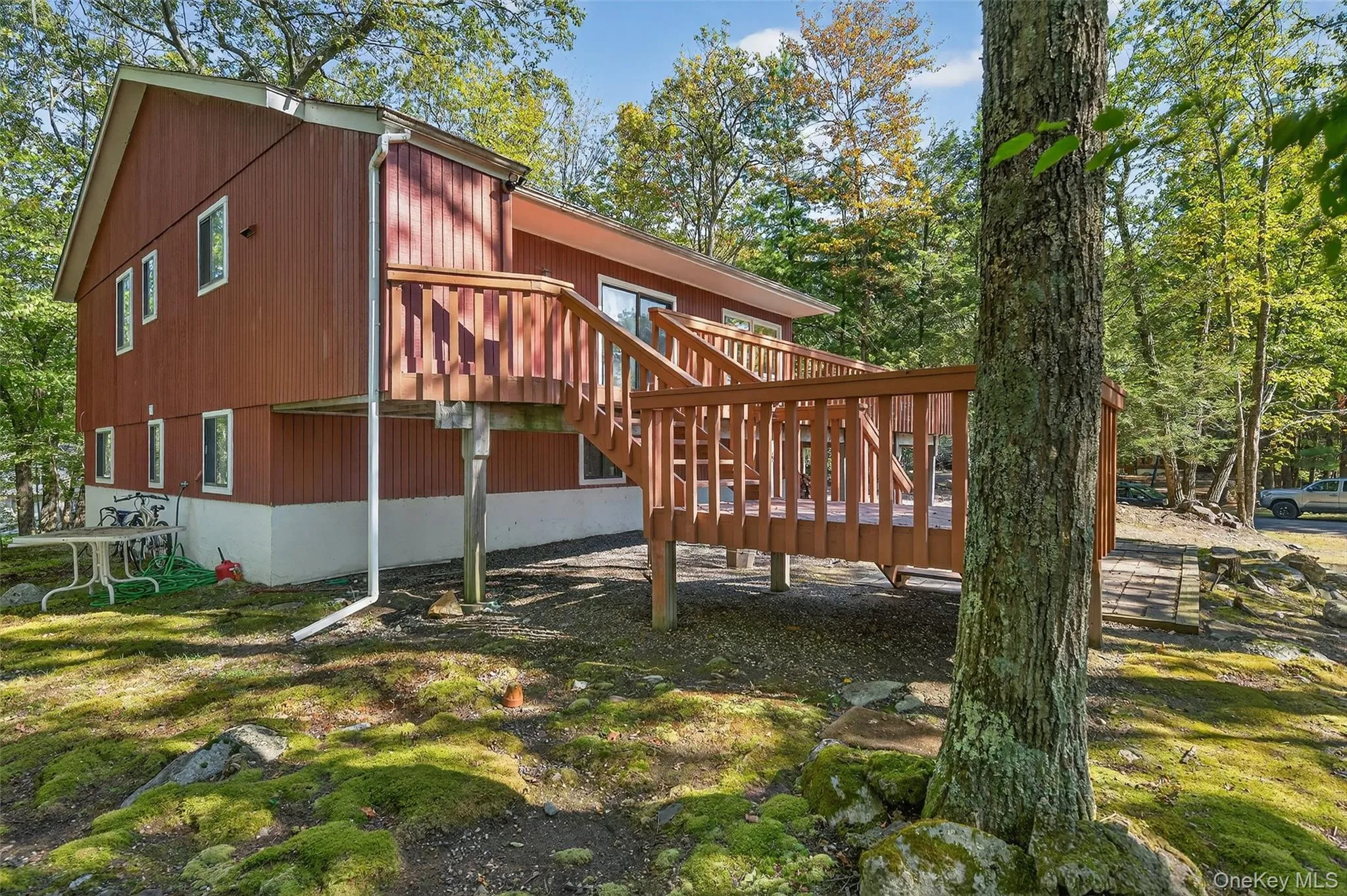 View of property exterior with stairway and a wooden deck View of property exterior with stairway and a wooden deck