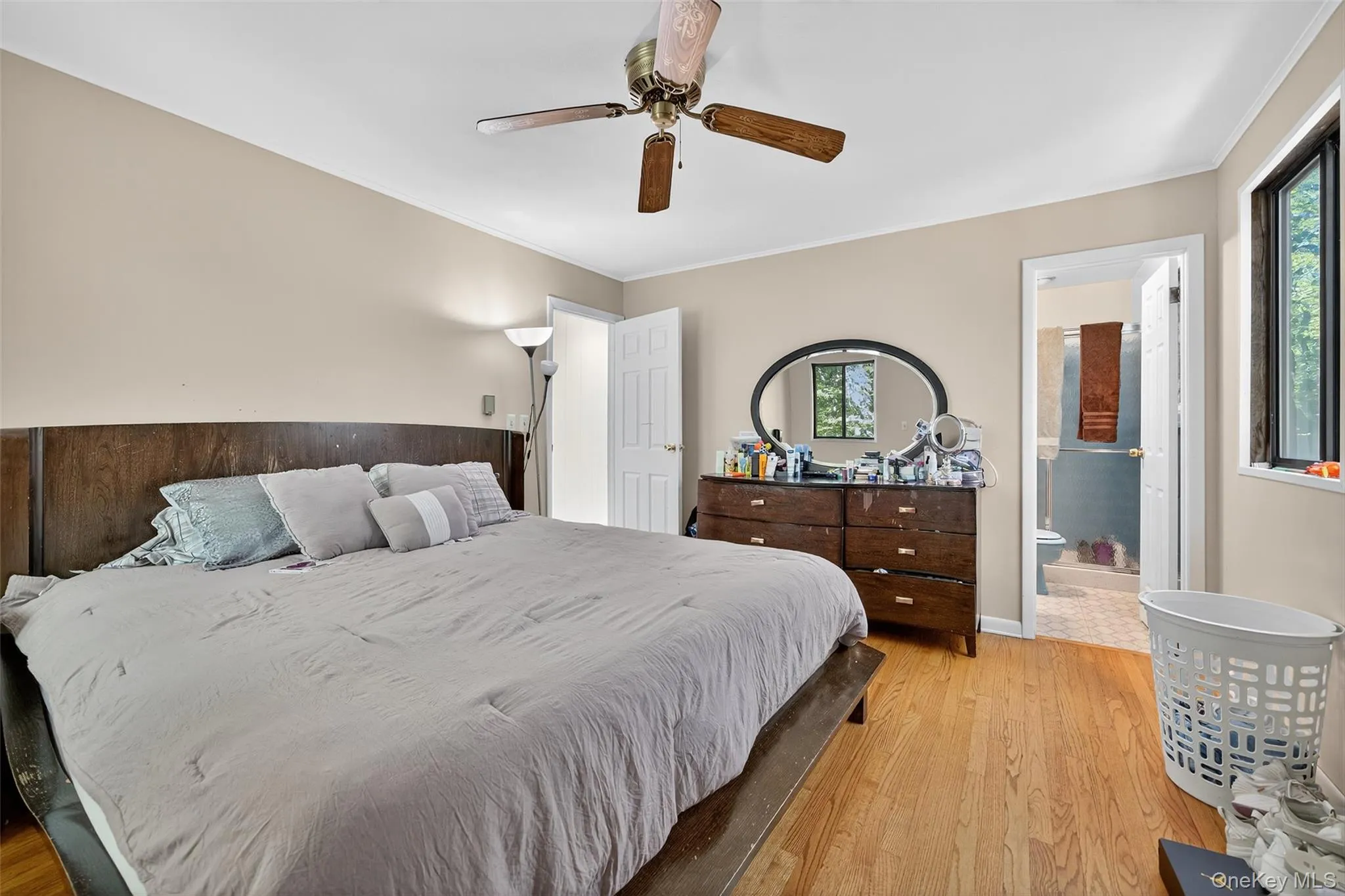 Bedroom with wood finished floors, ornamental molding, multiple windows, and ensuite bathroom Bedroom with wood finished floors, ornamental molding, multiple windows, and ensuite bathroom