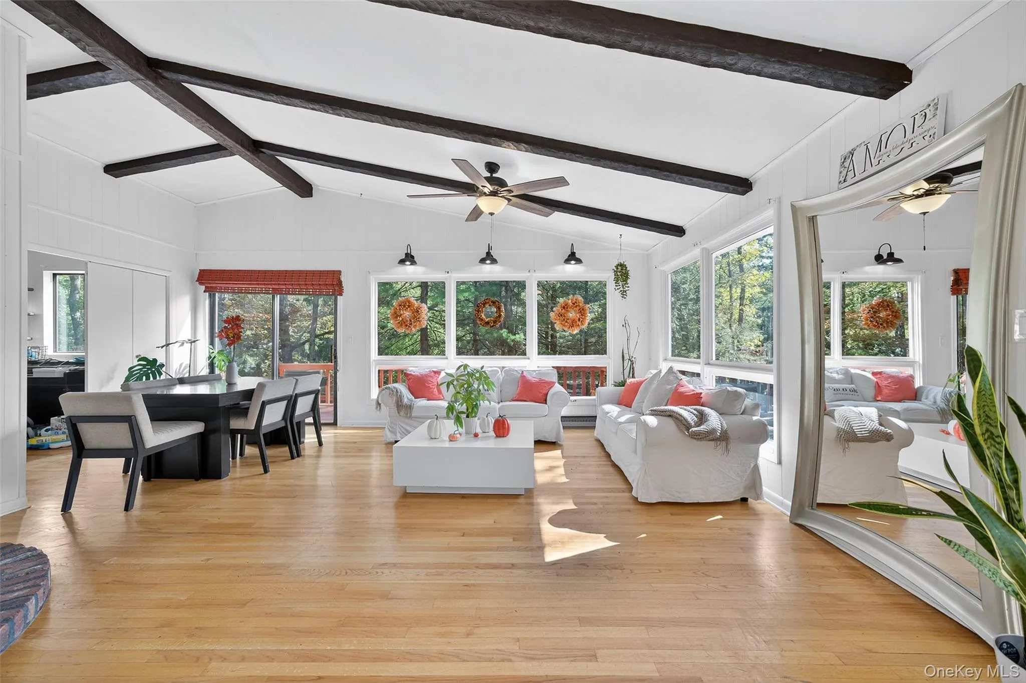 Living area with light wood-style flooring, ceiling fan, and healthy amount of natural light Living area with light wood-style flooring, ceiling fan, and healthy amount of natural light