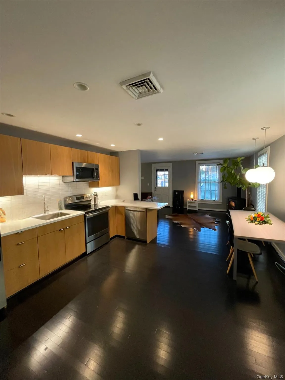 Kitchen with a peninsula, stainless steel appliances, light countertops, modern cabinets, and tasteful backsplash Kitchen with a peninsula, stainless steel appliances, light countertops, modern cabinets, and tasteful backsplash