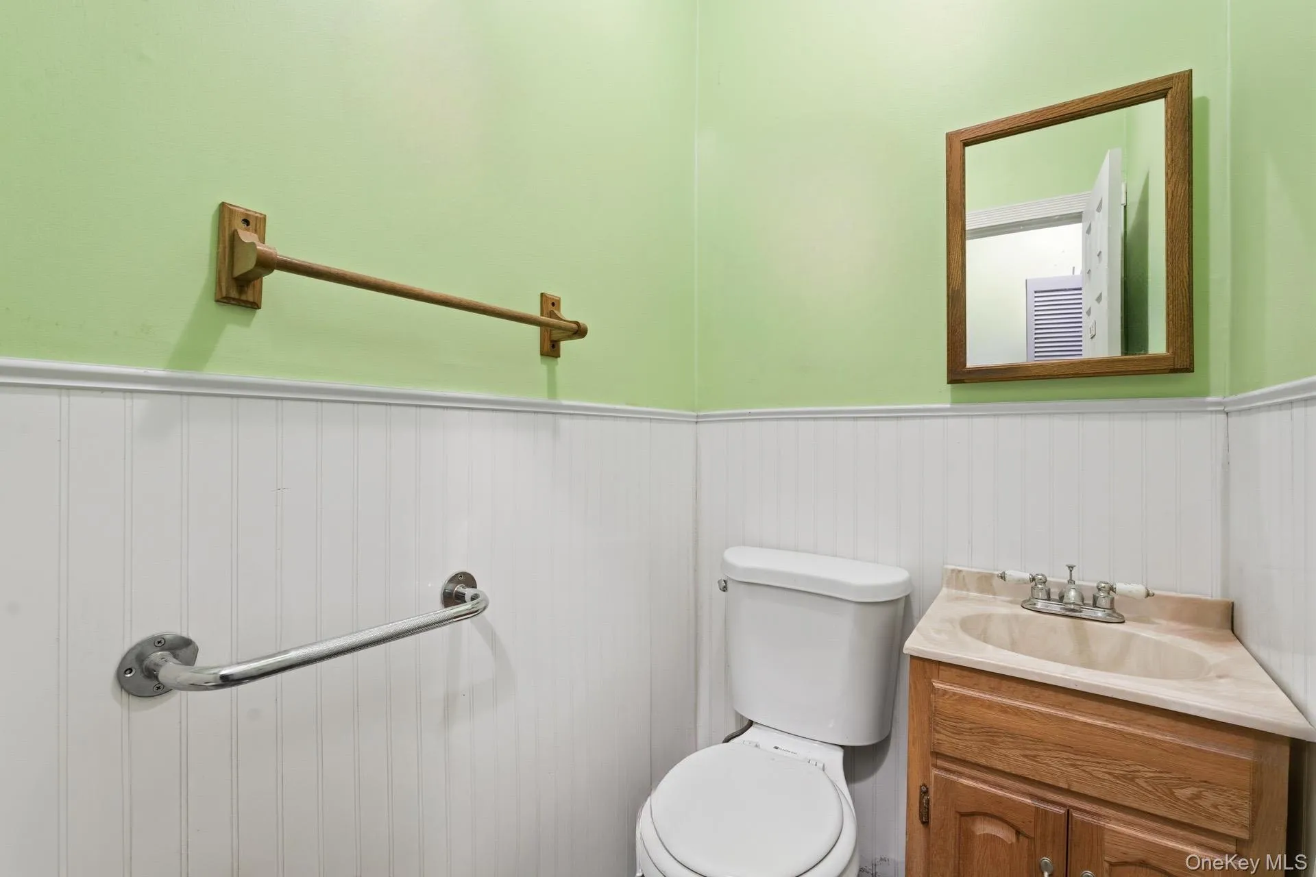 Half bath with wainscoting, vanity, and a decorative wall Half bath with wainscoting, vanity, and a decorative wall