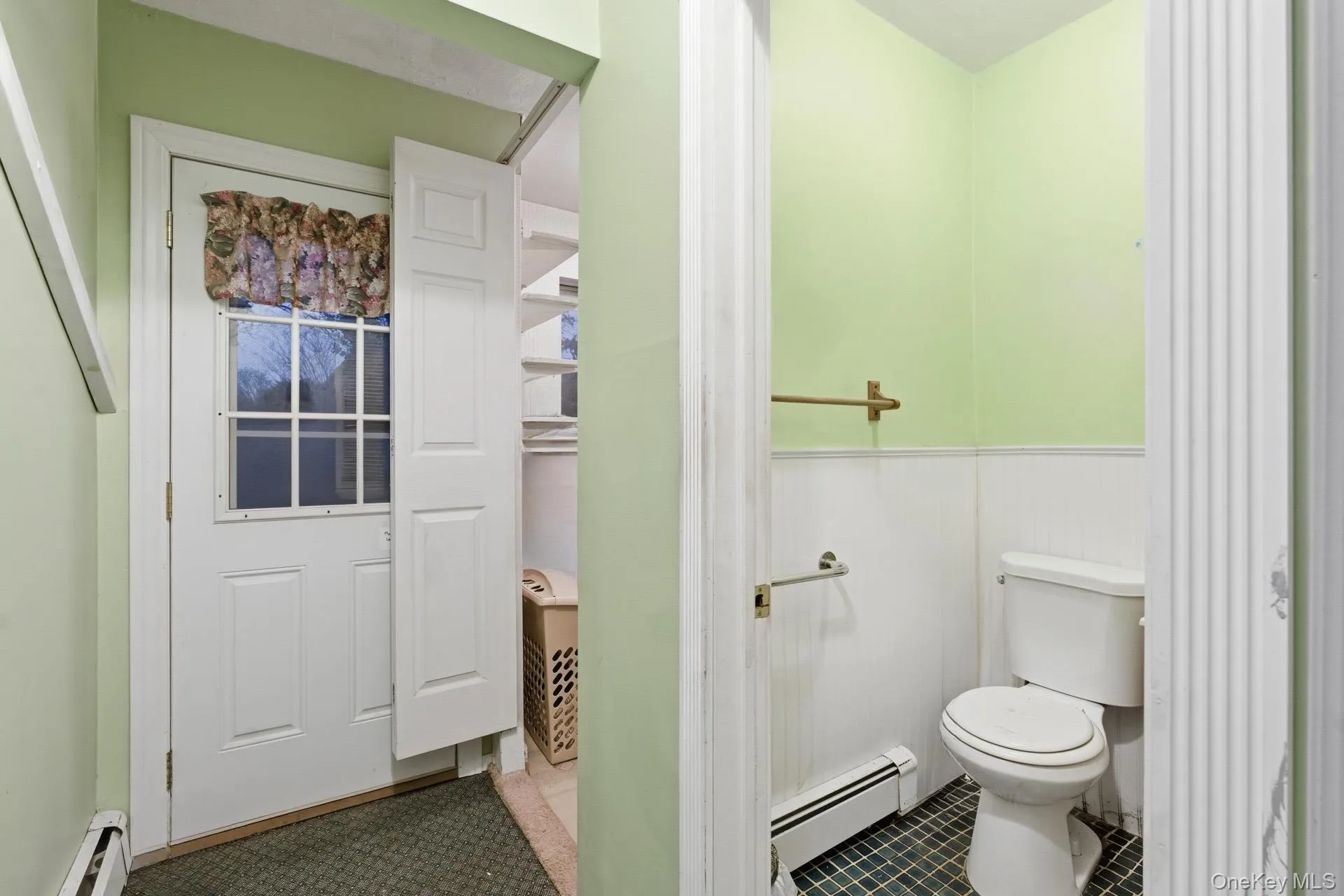 Bathroom with a baseboard heating unit, a wainscoted wall, and baseboard heating Bathroom with a baseboard heating unit, a wainscoted wall, and baseboard heating