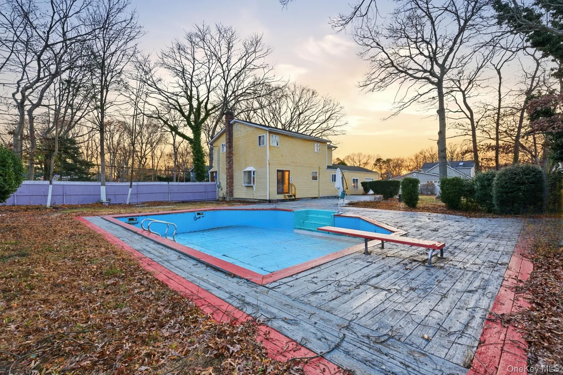 View of pool featuring a patio area, a diving board, and a wooden deck View of pool featuring a patio area, a diving board, and a wooden deck