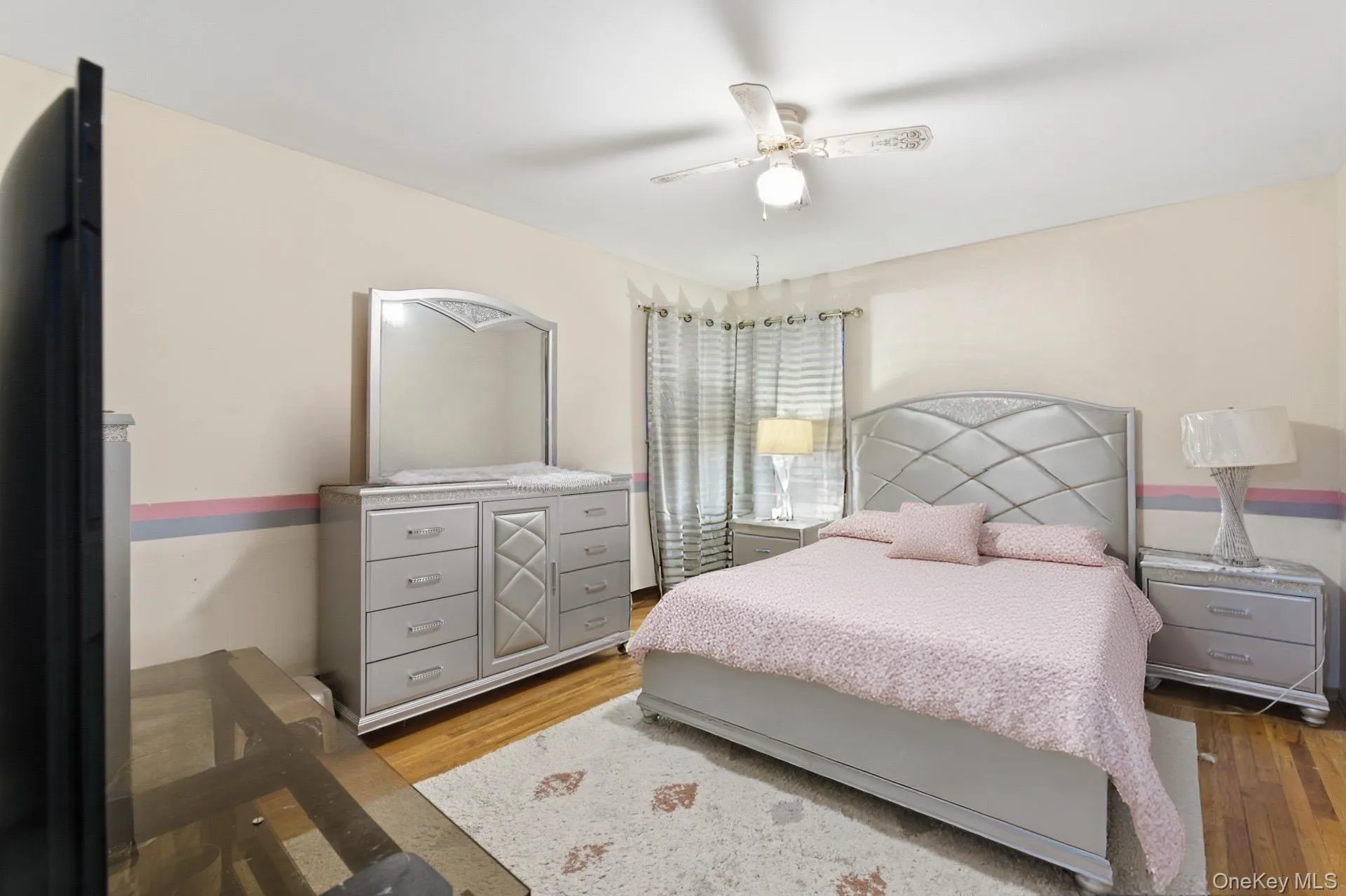 Bedroom with light wood-style flooring and a ceiling fan Bedroom with light wood-style flooring and a ceiling fan