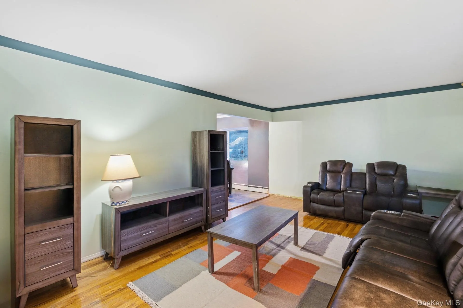 Living room with light wood-type flooring and a baseboard heating unit Living room with light wood-type flooring and a baseboard heating unit