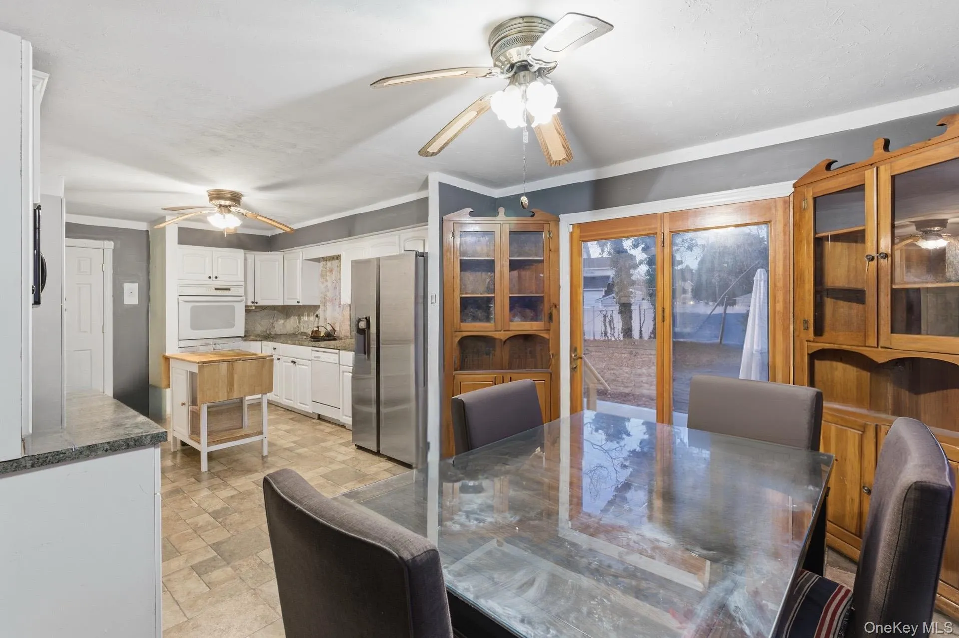 Dining area featuring stone finish floors, a ceiling fan, and ornamental molding Dining area featuring stone finish floors, a ceiling fan, and ornamental molding
