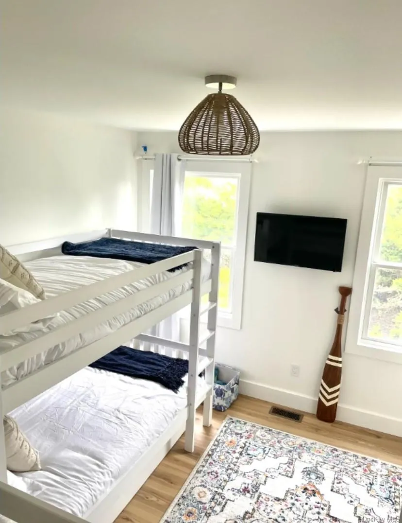 Bedroom featuring light wood finished floors and baseboards Bedroom featuring light wood finished floors and baseboards