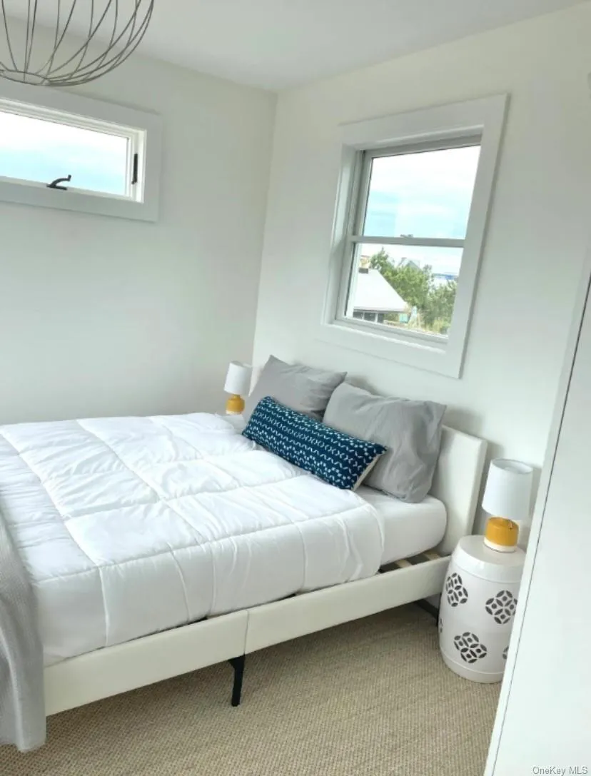 Carpeted bedroom featuring multiple windows Carpeted bedroom featuring multiple windows