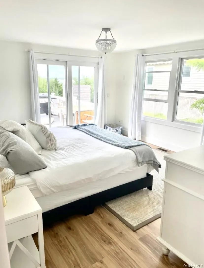 Bedroom with access to exterior and light wood-style flooring Bedroom with access to exterior and light wood-style flooring