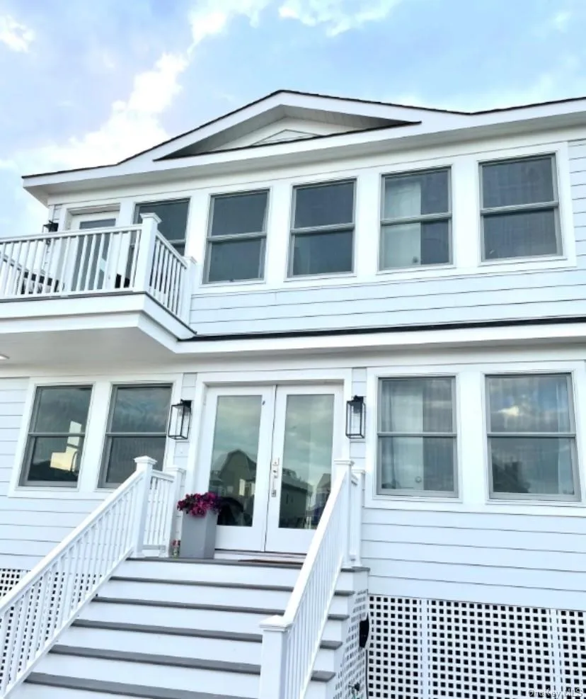 View of front of house featuring french doors and a balcony View of front of house featuring french doors and a balcony