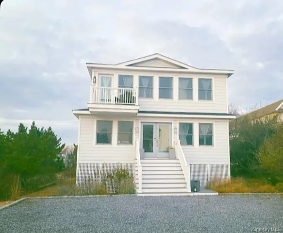 View of front of house with french doors and a balcony