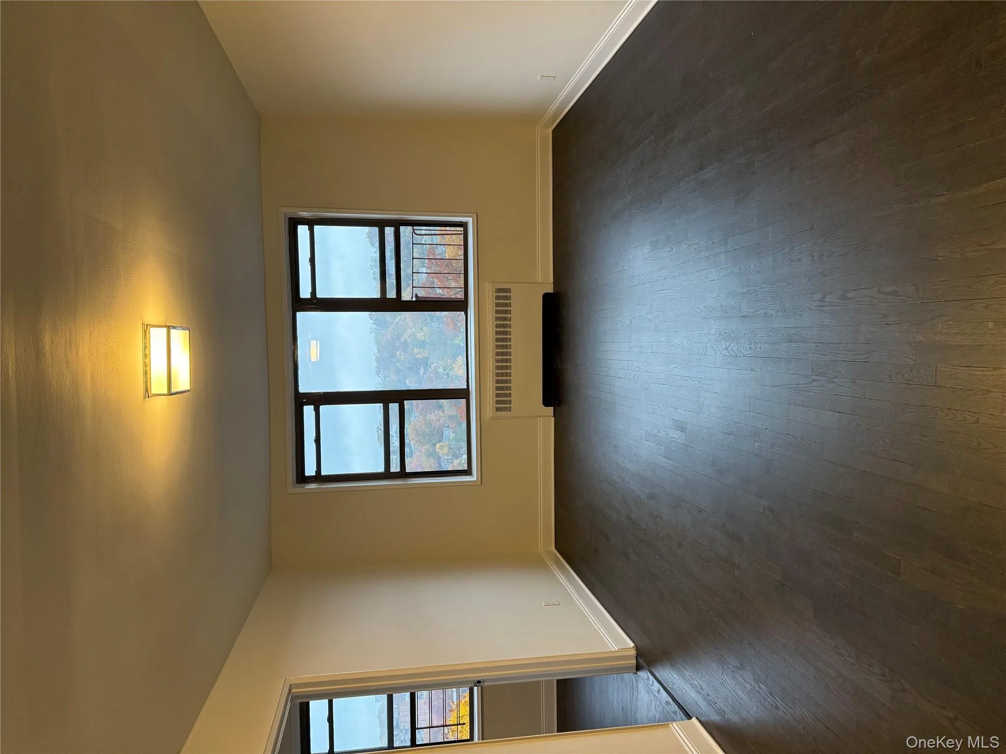 Empty room with radiator heating unit and dark wood finished floors Empty room with radiator heating unit and dark wood finished floors