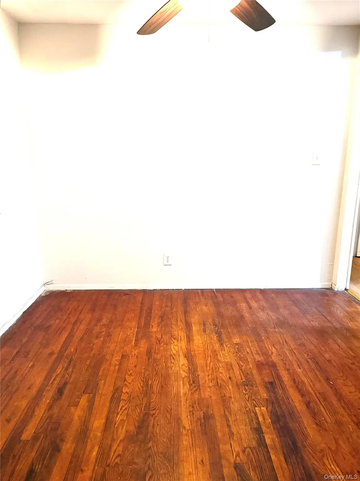 Unfurnished room with dark wood-style floors and ceiling fan Unfurnished room with dark wood-style floors and ceiling fan