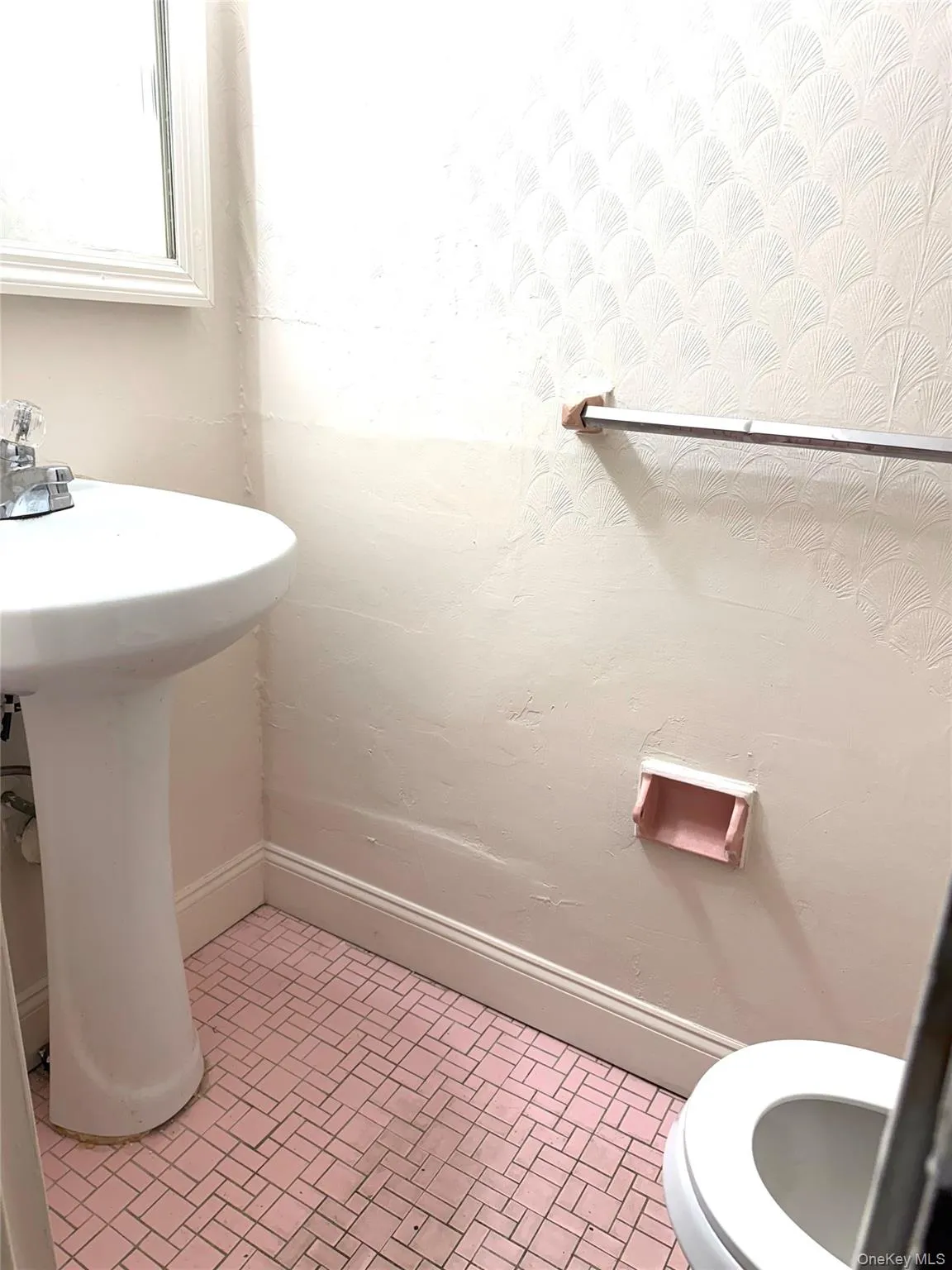 Bathroom with toilet and brick patterned floors Bathroom with toilet and brick patterned floors