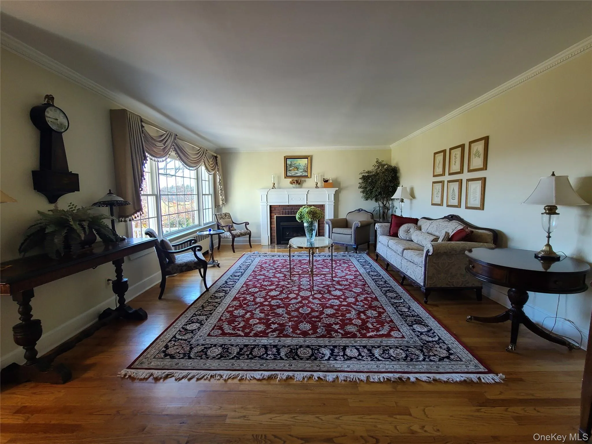 Living room with ornamental molding, a gas fireplace, and wood floors Living room with ornamental molding, a gas fireplace, and wood floors
