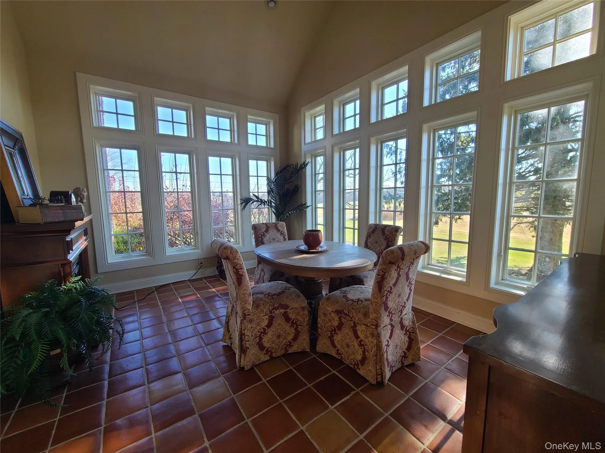 Dining room featuring high vaulted ceiling and dark tile patterned floors Dining room featuring high vaulted ceiling and dark tile patterned floors