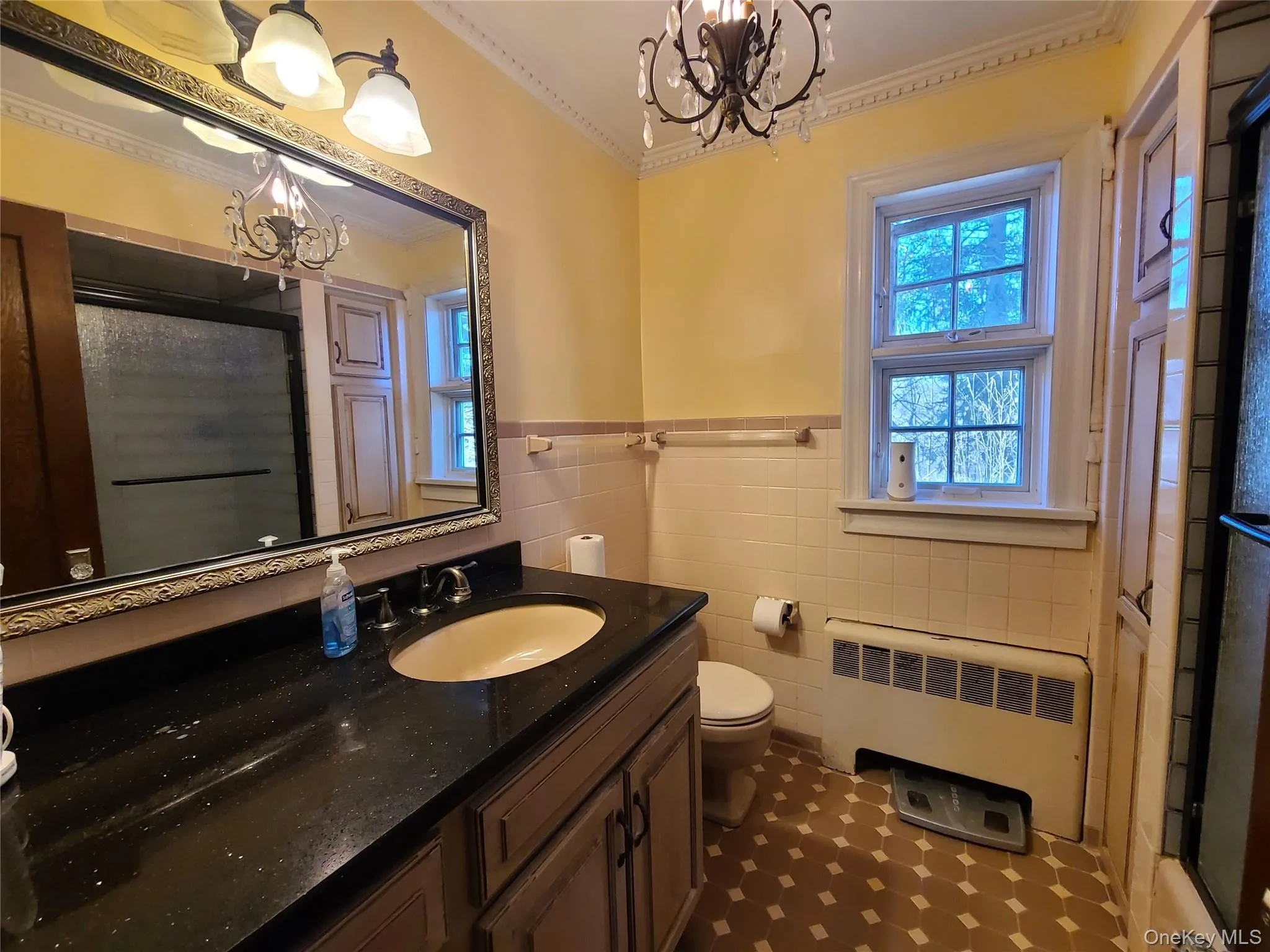 shower, radiator heating unit, vanity, a chandelier, and crown molding shower, radiator heating unit, vanity, a chandelier, and crown molding