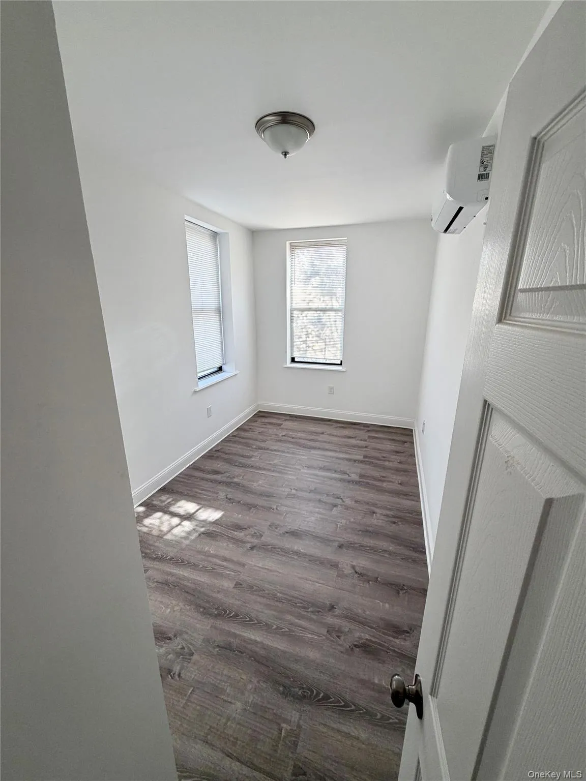Spare room featuring dark wood-type flooring and a wall mounted AC Spare room featuring dark wood-type flooring and a wall mounted AC