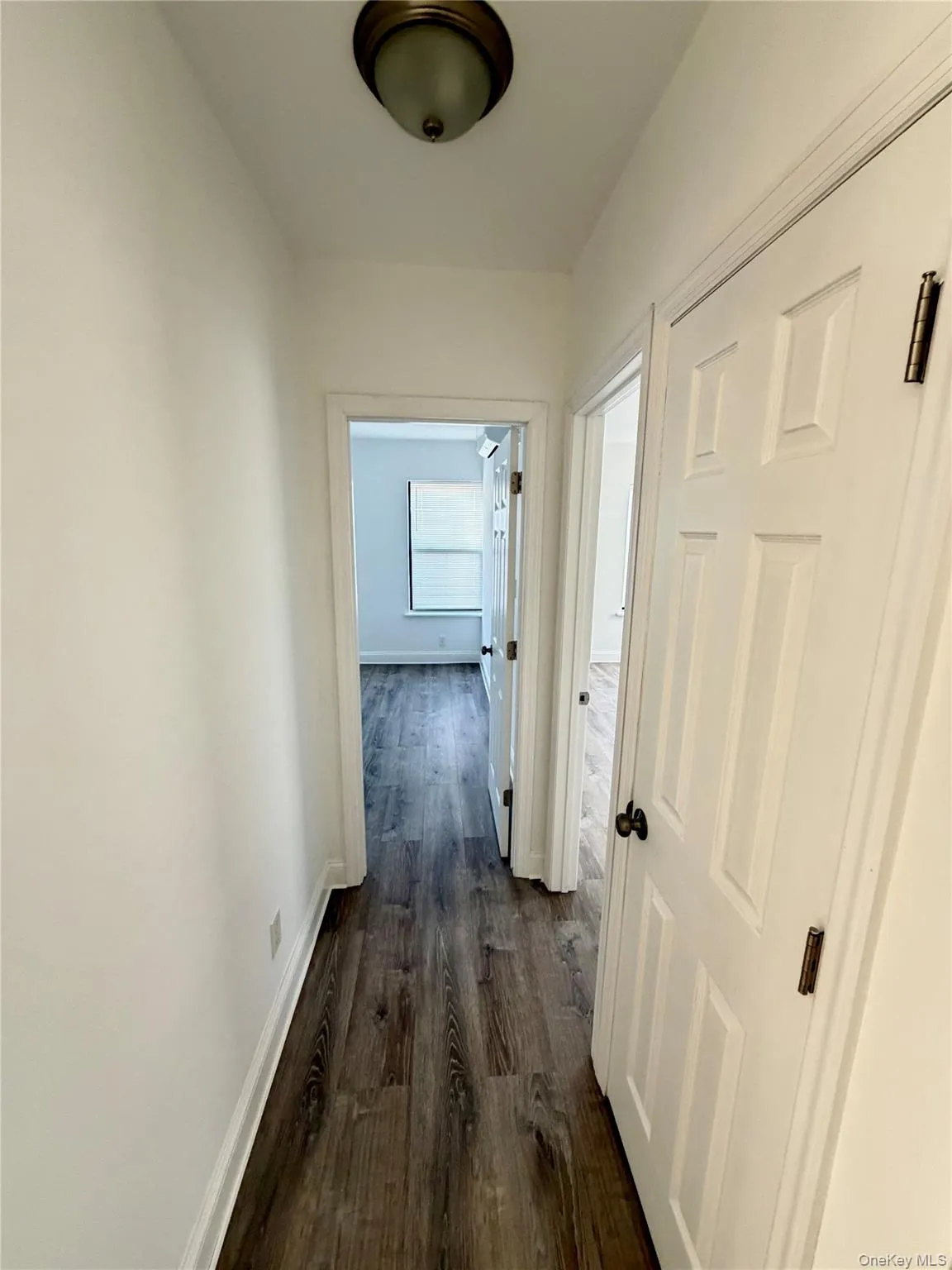 Hallway featuring dark wood-style floors and baseboards Hallway featuring dark wood-style floors and baseboards