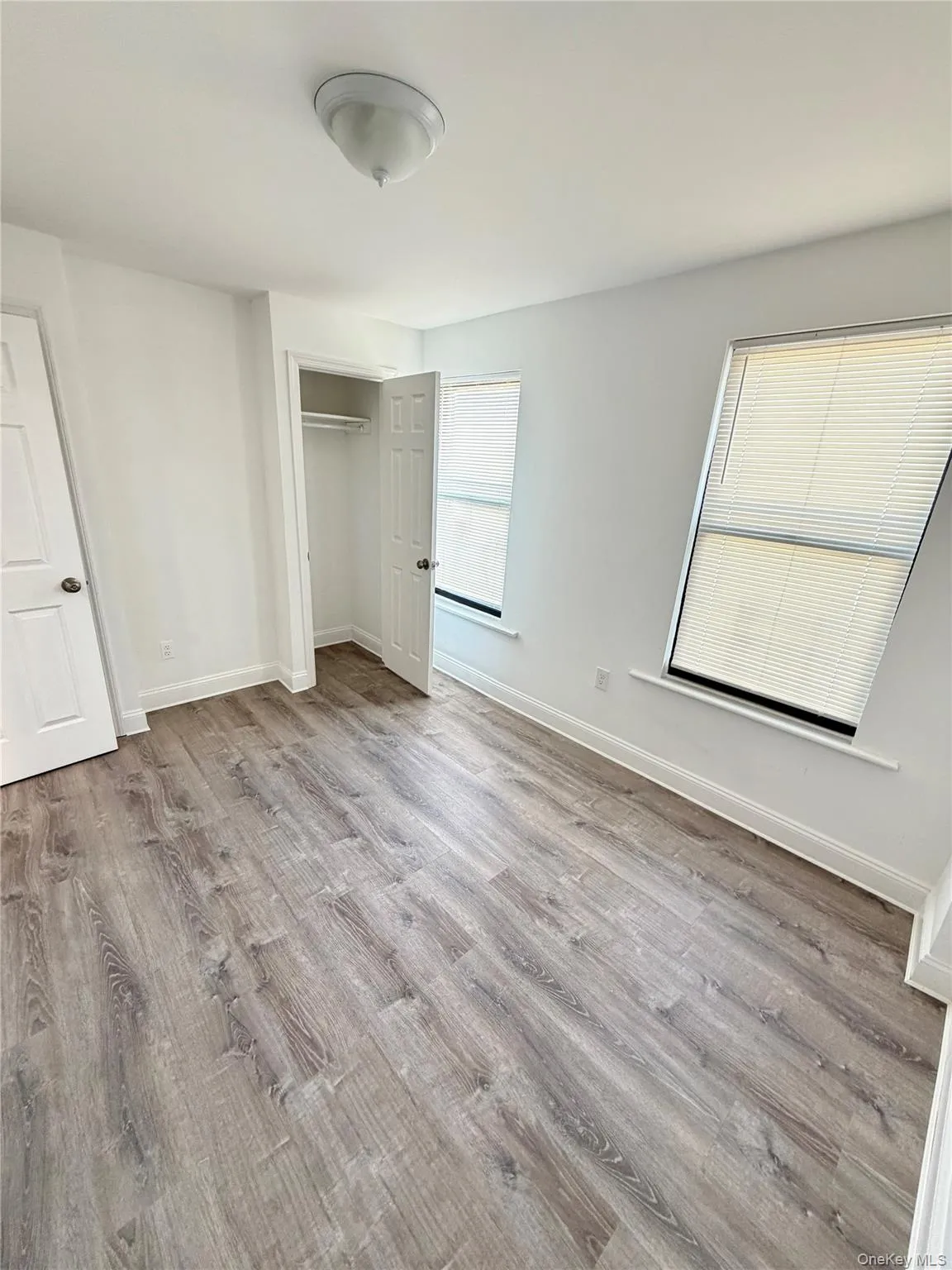 Unfurnished bedroom with light wood finished floors and a closet Unfurnished bedroom with light wood finished floors and a closet