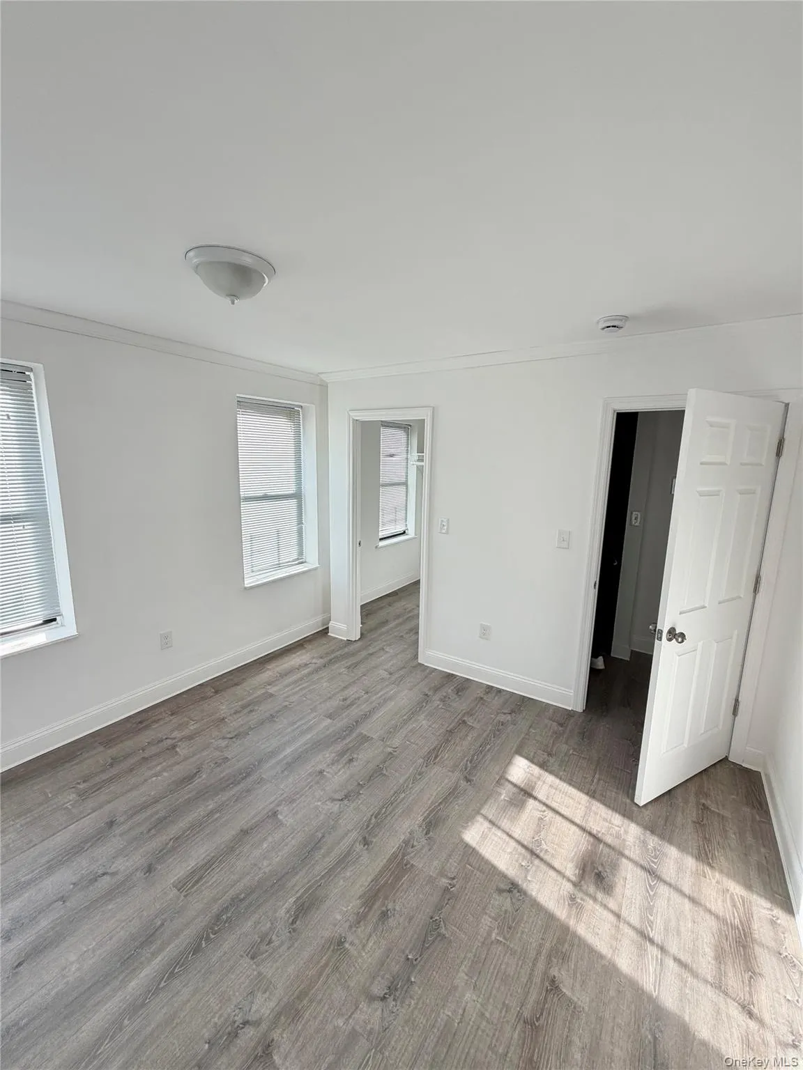 Unfurnished bedroom with light wood-type flooring and ornamental molding Unfurnished bedroom with light wood-type flooring and ornamental molding