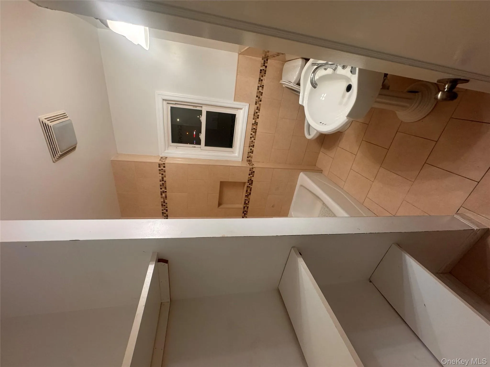 Full bathroom with tile walls, light tile patterned flooring, shower / bath combination, and wainscoting Full bathroom with tile walls, light tile patterned flooring, shower / bath combination, and wainscoting