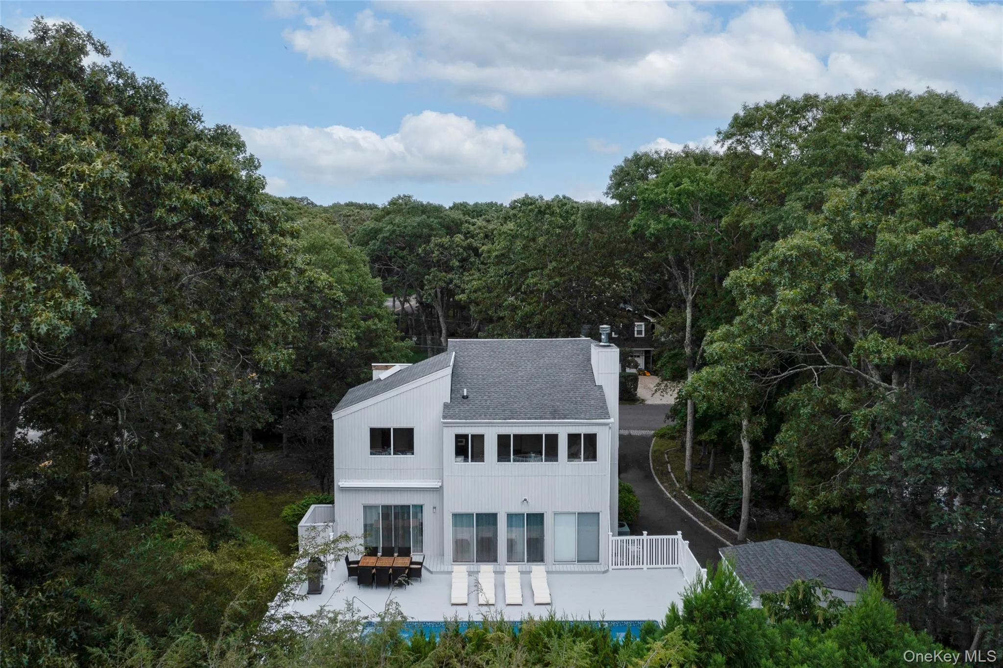 Back of property with a view of trees and a chimney Back of property with a view of trees and a chimney