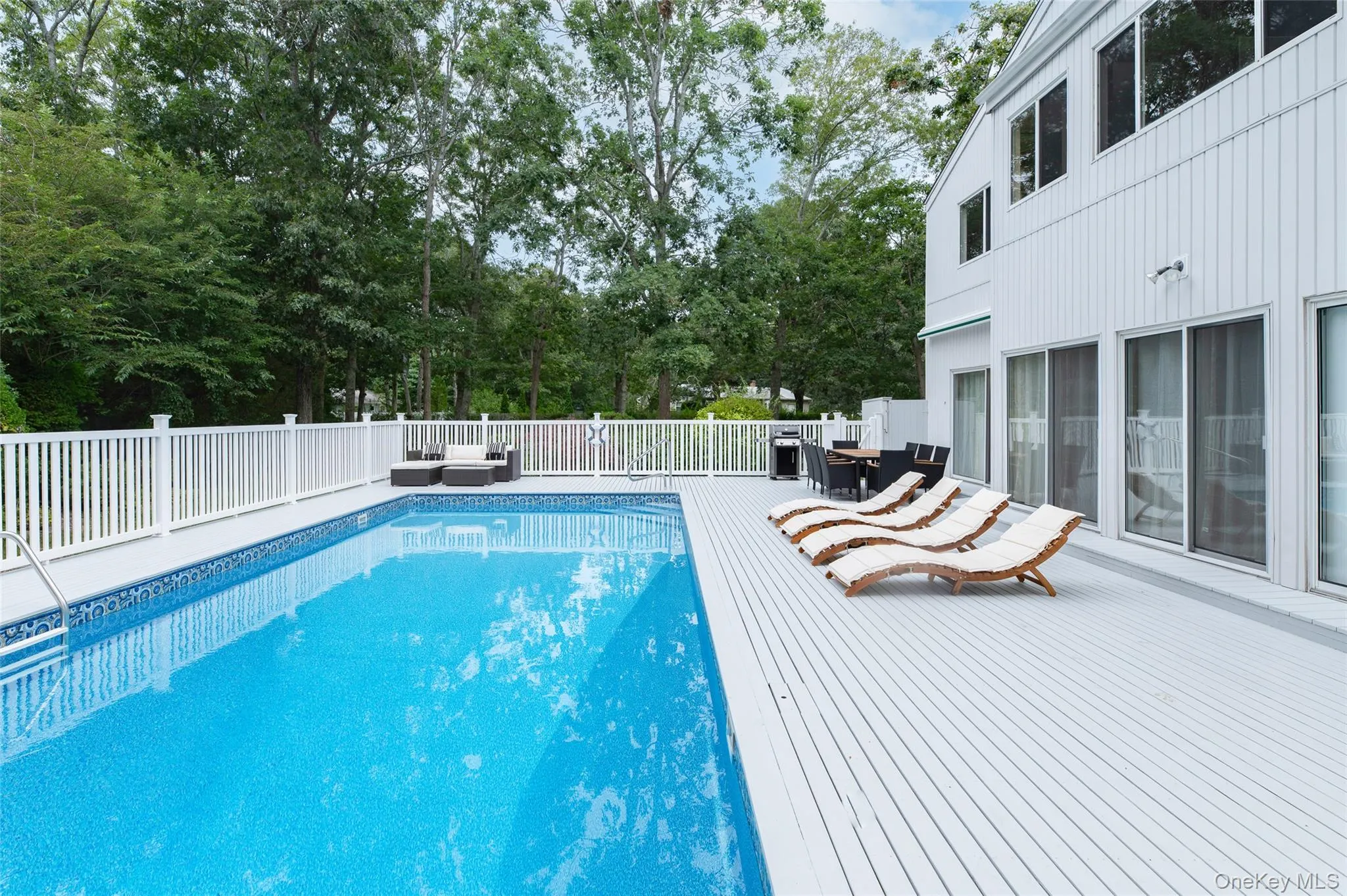 View of swimming pool featuring outdoor dining space, a wooden deck, and an outdoor hangout area View of swimming pool featuring outdoor dining space, a wooden deck, and an outdoor hangout area