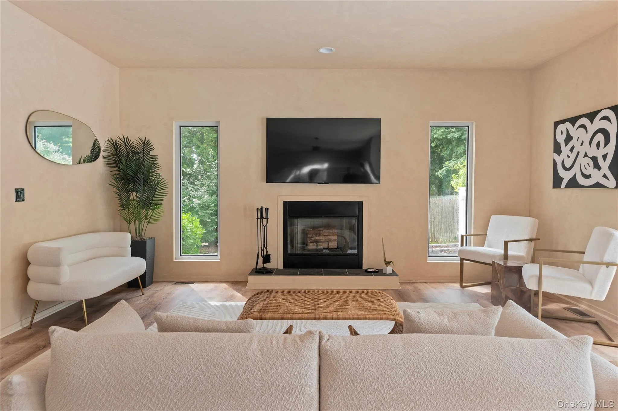 Living room featuring a glass covered fireplace, plenty of natural light, and wood finished floors Living room featuring a glass covered fireplace, plenty of natural light, and wood finished floors