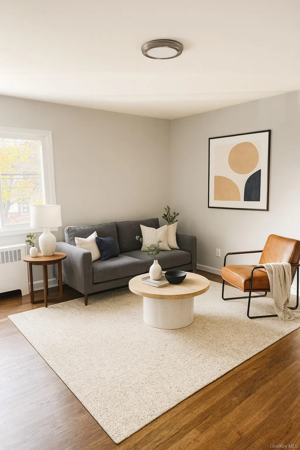 Living area with wood finished floors and radiator heating unit Living area with wood finished floors and radiator heating unit