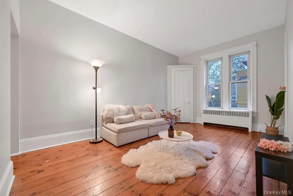 Living area with radiator and reclaimed wood floors. Living area with radiator and reclaimed wood floors.