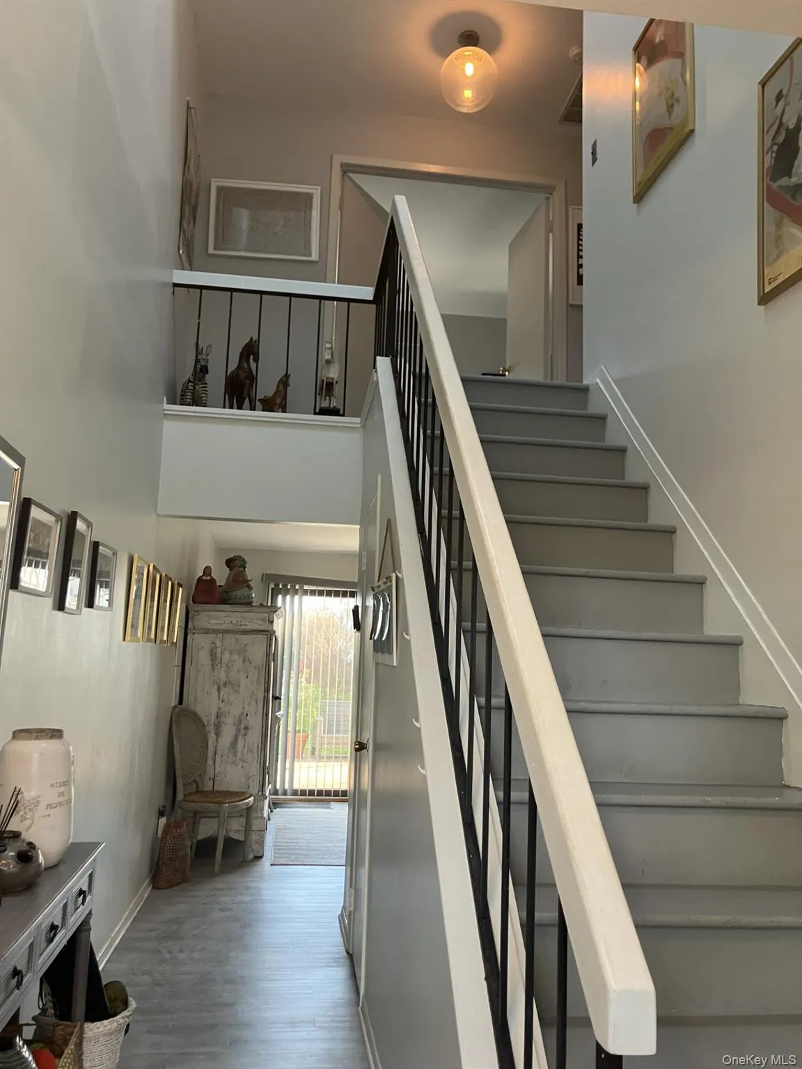 Stairway featuring wood finished floors and a towering ceiling Stairway featuring wood finished floors and a towering ceiling