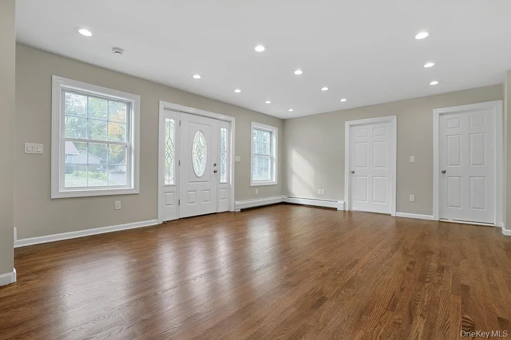 Entryway featuring recessed lighting, healthy amount of natural light, dark wood-style flooring, and a baseboard heating unit Entryway featuring recessed lighting, healthy amount of natural light, dark wood-style flooring, and a baseboard heating unit