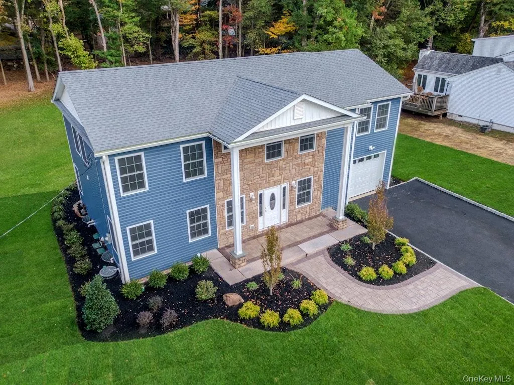 View of front of house featuring a front lawn, a shingled roof, asphalt driveway, and a garage View of front of house featuring a front lawn, a shingled roof, asphalt driveway, and a garage