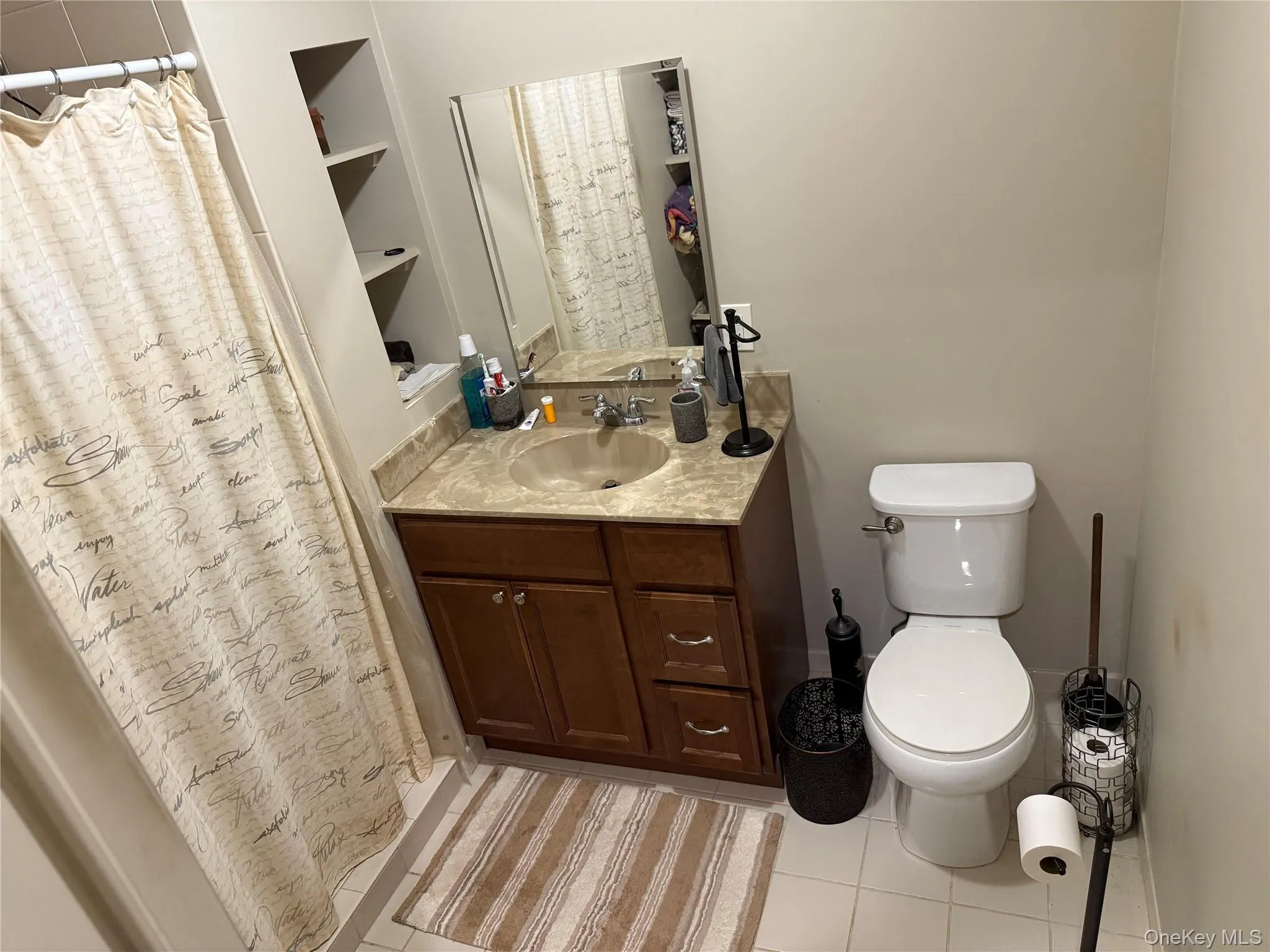 2nd full bathroom featuring a shower with curtain, vanity, and light tile patterned floors. 2nd full bathroom featuring a shower with curtain, vanity, and light tile patterned floors.