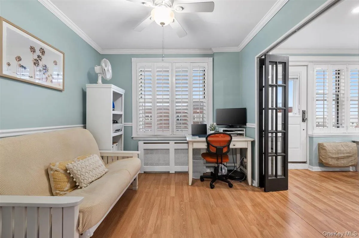 Office with radiator heating unit, a ceiling fan, wood finished floors, and ornamental molding Office with radiator heating unit, a ceiling fan, wood finished floors, and ornamental molding