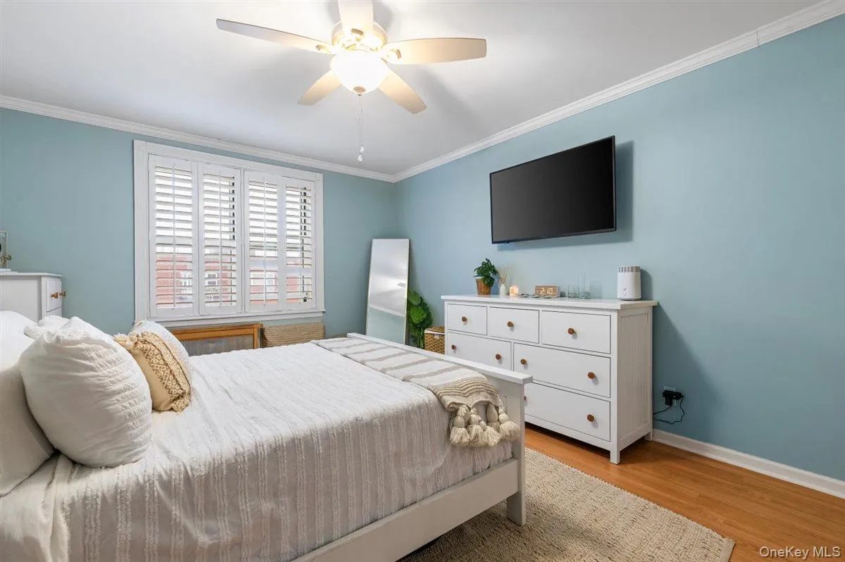 Bedroom featuring ornamental molding, light wood-type flooring, and ceiling fan Bedroom featuring ornamental molding, light wood-type flooring, and ceiling fan