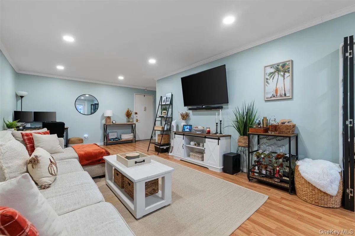 Living area with ornamental molding, light wood-style flooring, recessed lighting, and an office area Living area with ornamental molding, light wood-style flooring, recessed lighting, and an office area