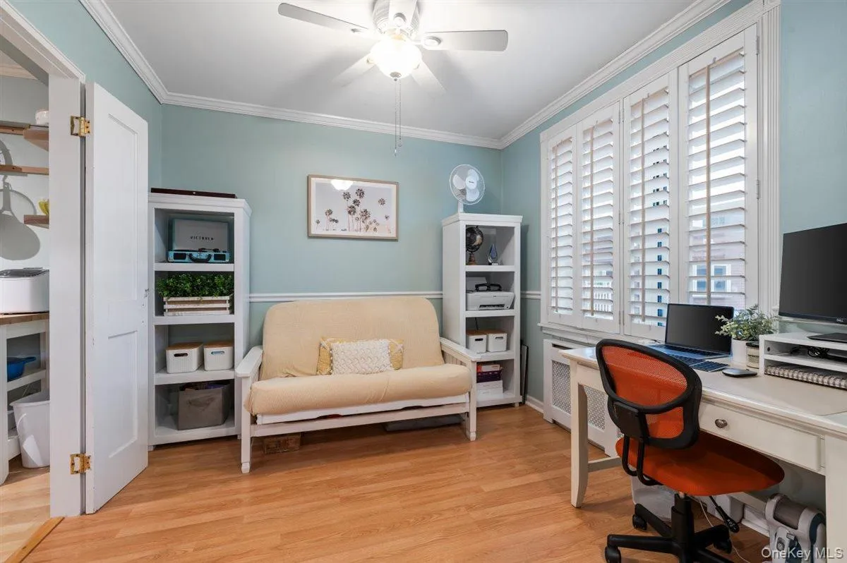 Home office featuring light wood finished floors, radiator, ornamental molding, and ceiling fan Home office featuring light wood finished floors, radiator, ornamental molding, and ceiling fan