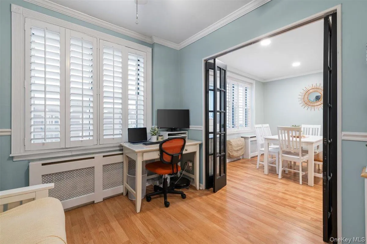 Home office featuring radiator heating unit, light wood finished floors, and crown molding Home office featuring radiator heating unit, light wood finished floors, and crown molding
