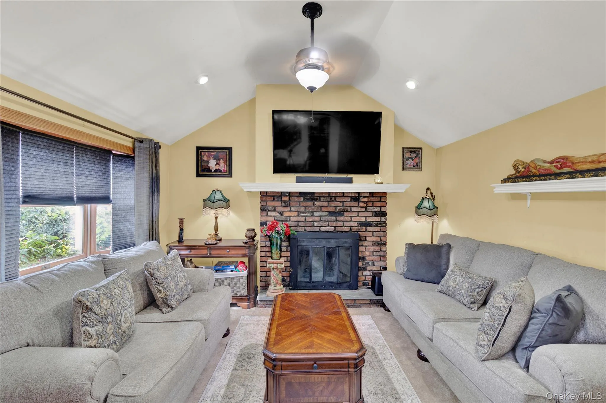 Living area with vaulted ceiling and a brick fireplace Living area with vaulted ceiling and a brick fireplace