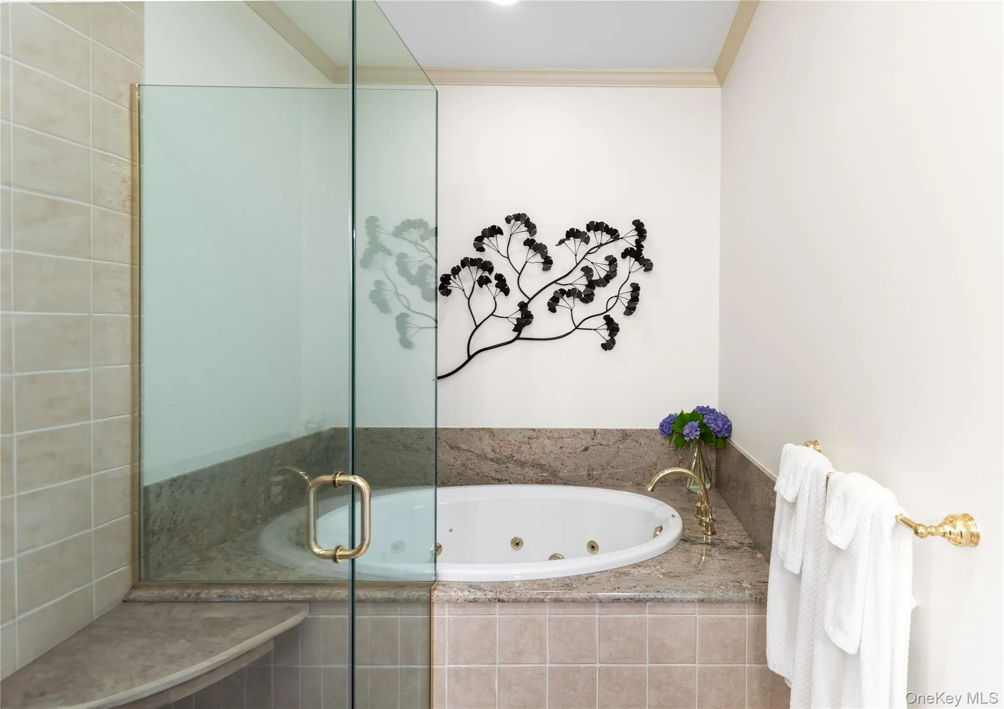 Full bath with a stall shower, a tub with jets, and ornamental molding Full bath with a stall shower, a tub with jets, and ornamental molding