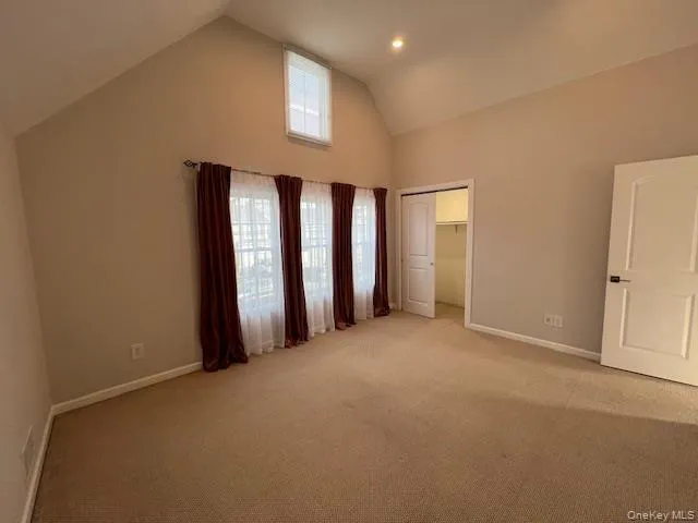 Unfurnished bedroom with high Bedroom#3 with vaulted ceiling, a closet, and light carpet Unfurnished bedroom with high Bedroom#3 with vaulted ceiling, a closet, and light carpet