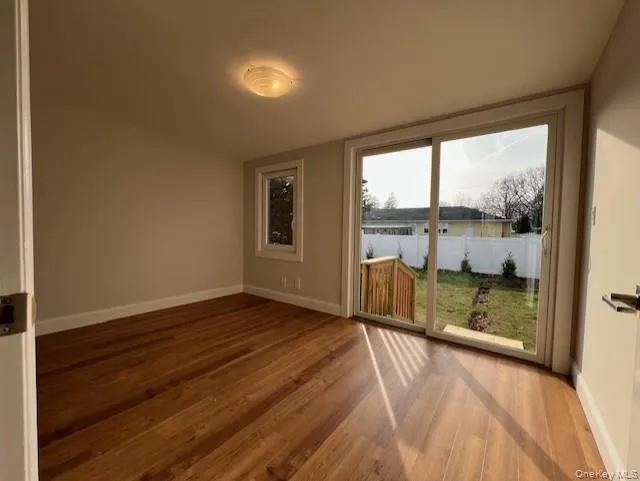 Bedroom with sliding door, wood finished floors and baseboards Bedroom with sliding door, wood finished floors and baseboards