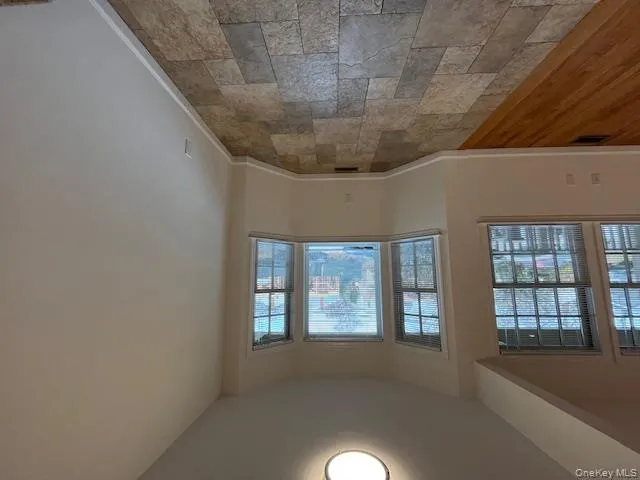 Unfurnished room featuring baseboards and stone tile flooring Unfurnished room featuring baseboards and stone tile flooring