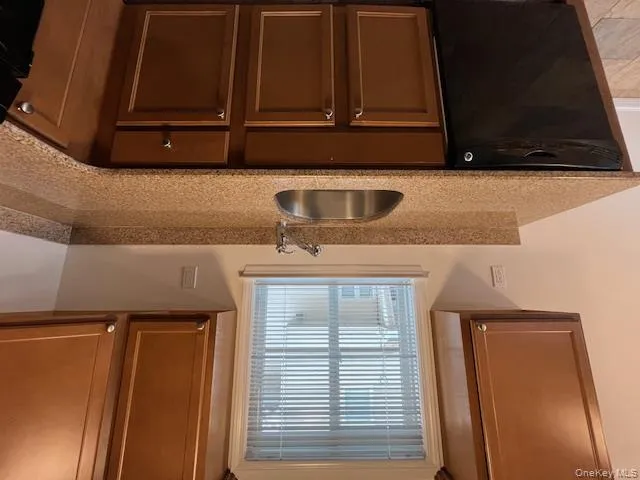 Kitchen featuring dishwasher, light stone countertops, light tile patterned floors, and stove Kitchen featuring dishwasher, light stone countertops, light tile patterned floors, and stove