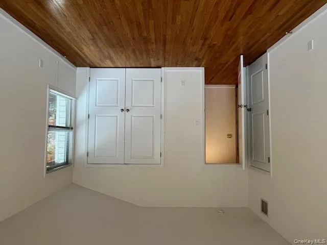 Unfurnished bedroom with lofted ceiling, dark wood finished floors, and a closet Unfurnished bedroom with lofted ceiling, dark wood finished floors, and a closet